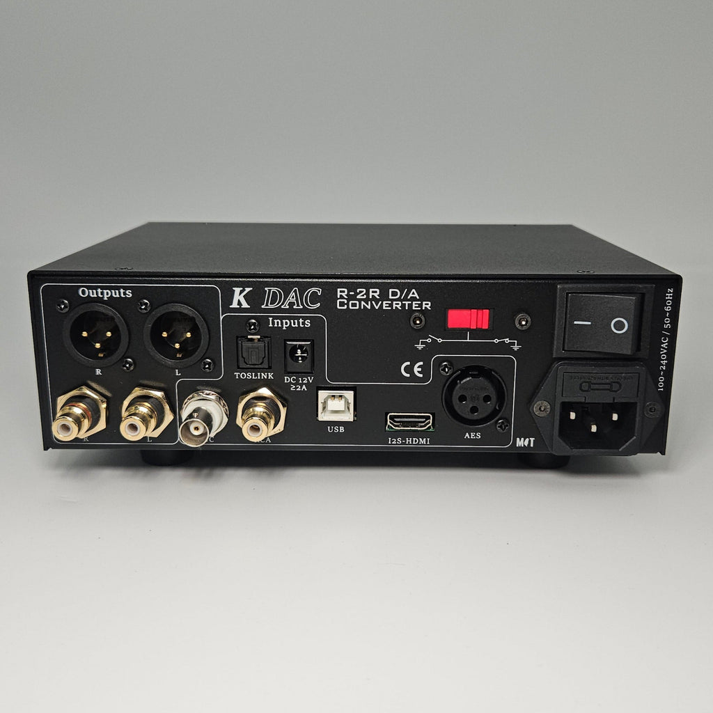 Back panel of an audio equipment unit with various connectors on a gray background